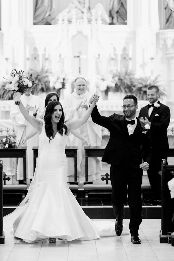 Bride and groom walking down the aisle as a married couple at St Peter's Parish