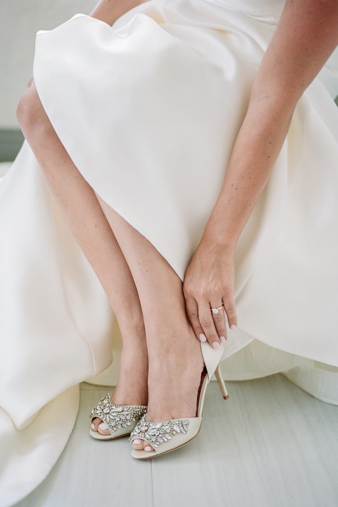 Bride putting on her badgley mischka shoes