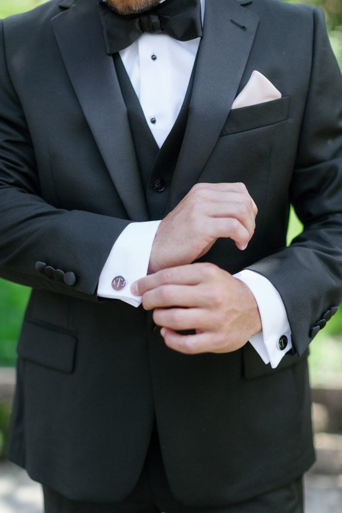 Groom fixing his cufflinks outside his home in pittsburgh