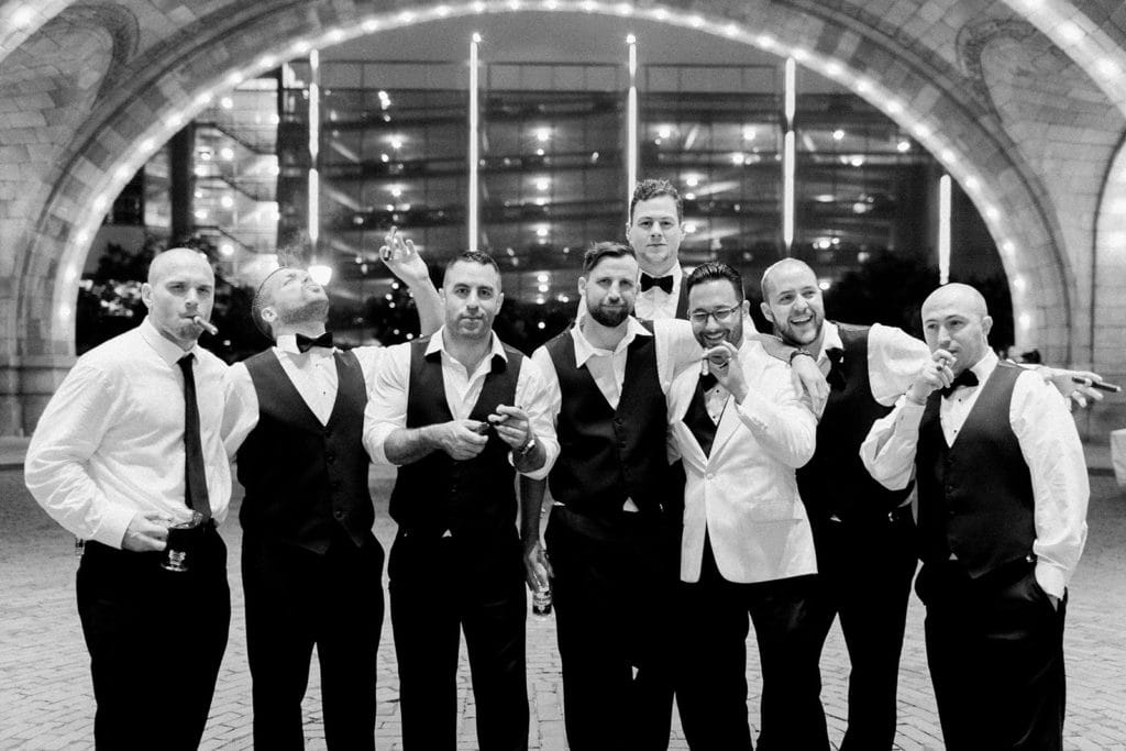 Groomsmen enjoying cigars outside in the rotunda of the Pennsylvanian