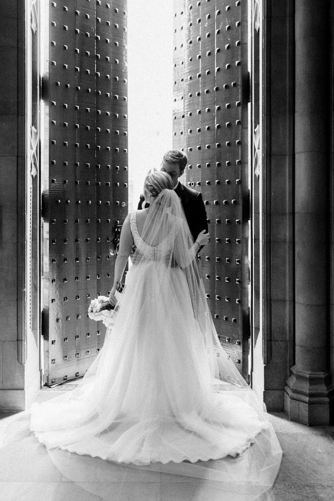 Black and white photo of bride and groom portraits inside Heinz Chapel