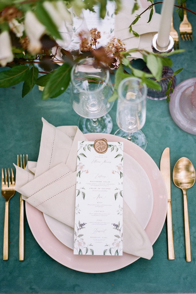 The tent merchant rentals with pink plates and gold flatware