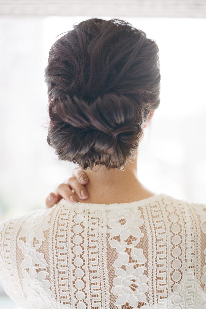 Bride wearing a lace robe while getting ready the morning of her wedding