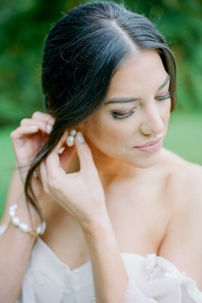 Bride putting in her earrings during getting ready