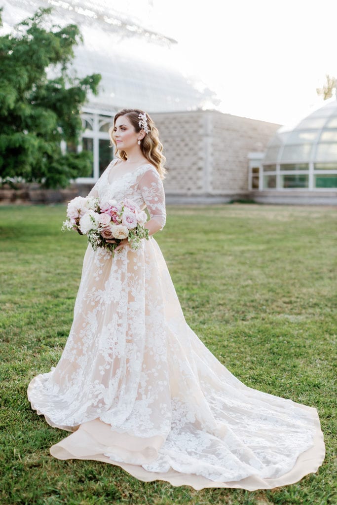 Bride wearing a Jaclyn Jordan wedding gown holding a pink and mauve bouquet