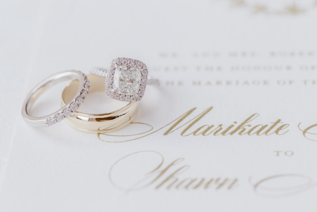 Close up photo of wedding rings on invitations by Nota Bene