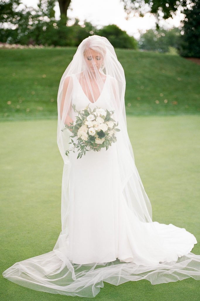 Portrait of just the bride in her watters dress and veil