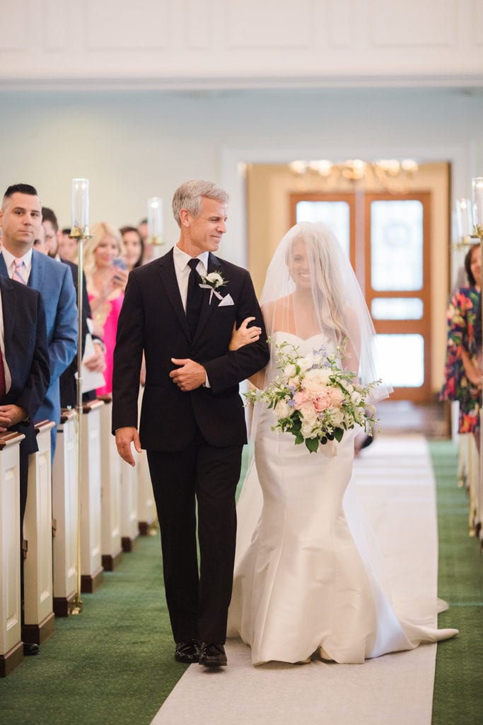 Father looking at daughter as he escorts her down the aisle