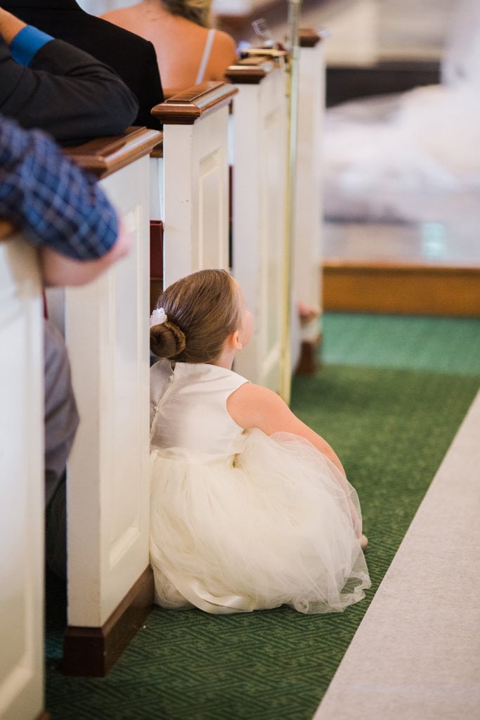 Flower girl sitting during Fox Chapel wedding ceremony