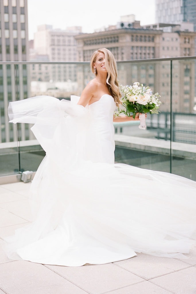 Bride twirling in Bridal Beginning wedding dresson Hotel Monaco rooftop