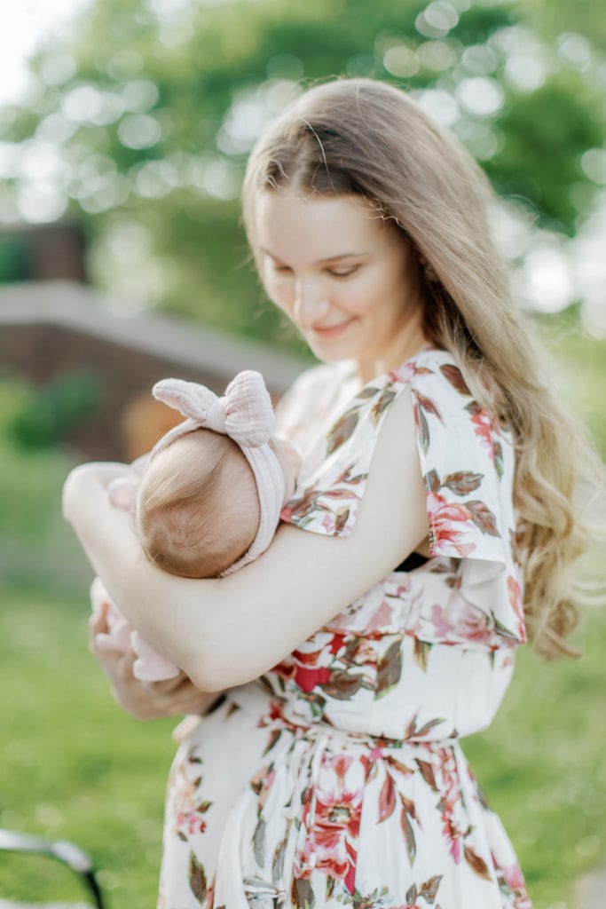 mother cradling her newborn baby girl: outdoor newborn session