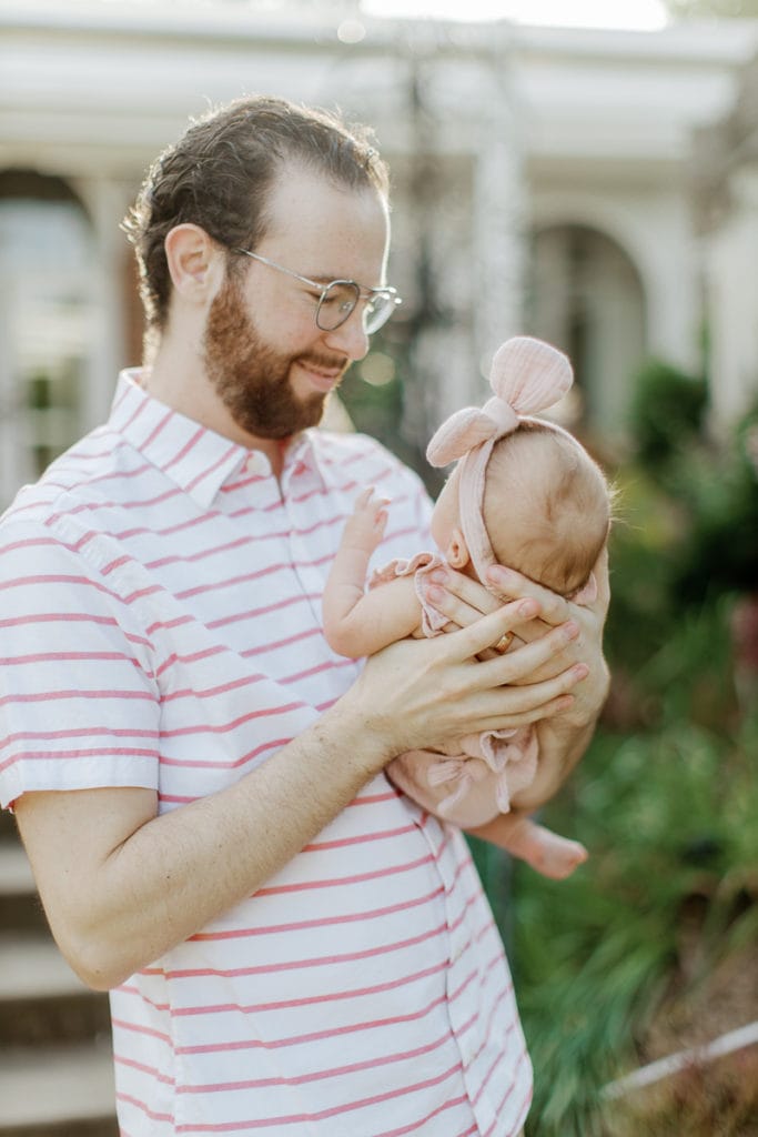 Father holding his newborn baby girl in mellon park: outdoor newborn session