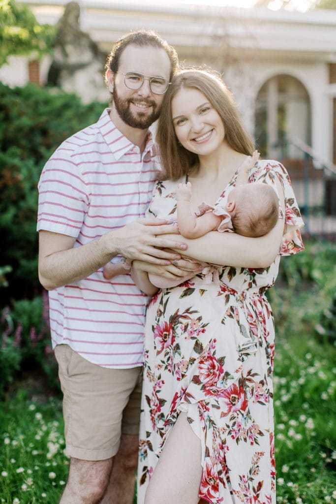 Parent's holding their newborn hugging and smiling at the camera: outdoor newborn session: outdoor newborn session