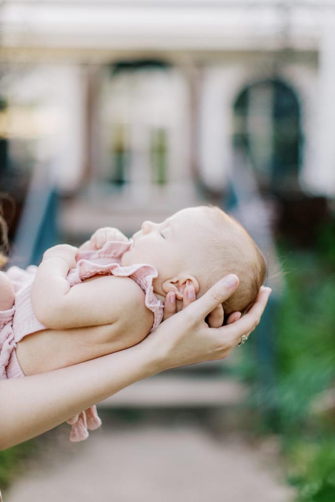 image of newborn baby being cradled in her mother's arms: outdoor newborn session