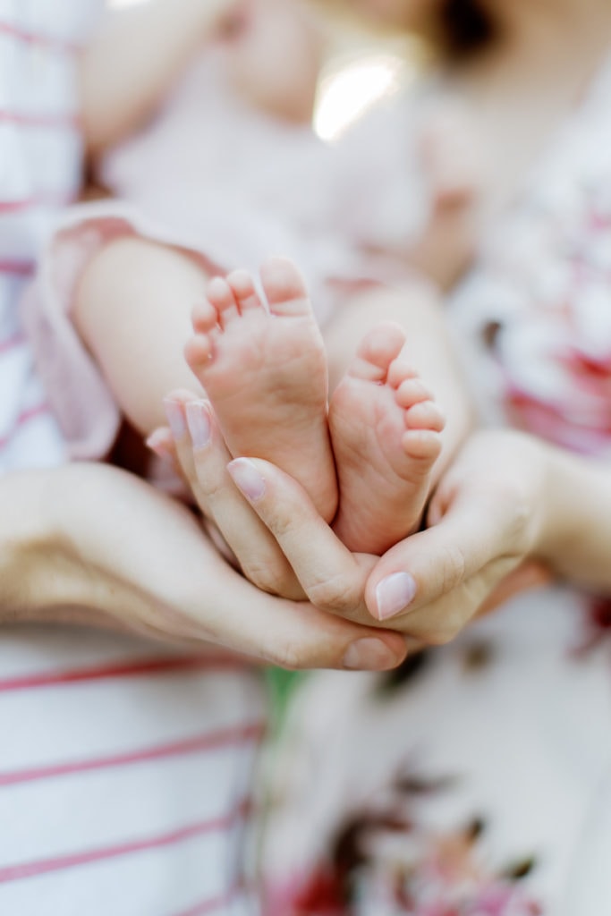 close up of parents holding their baby's feet: outdoor newborn session