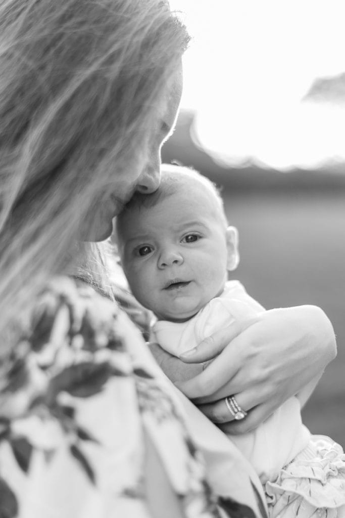 black and white photo of mother snuggling her newborn baby: outdoor newborn session