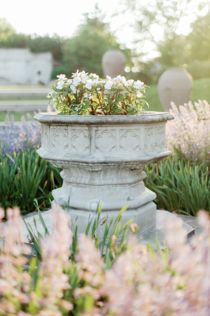 White flowers in stone urn inside english garden at mellon park