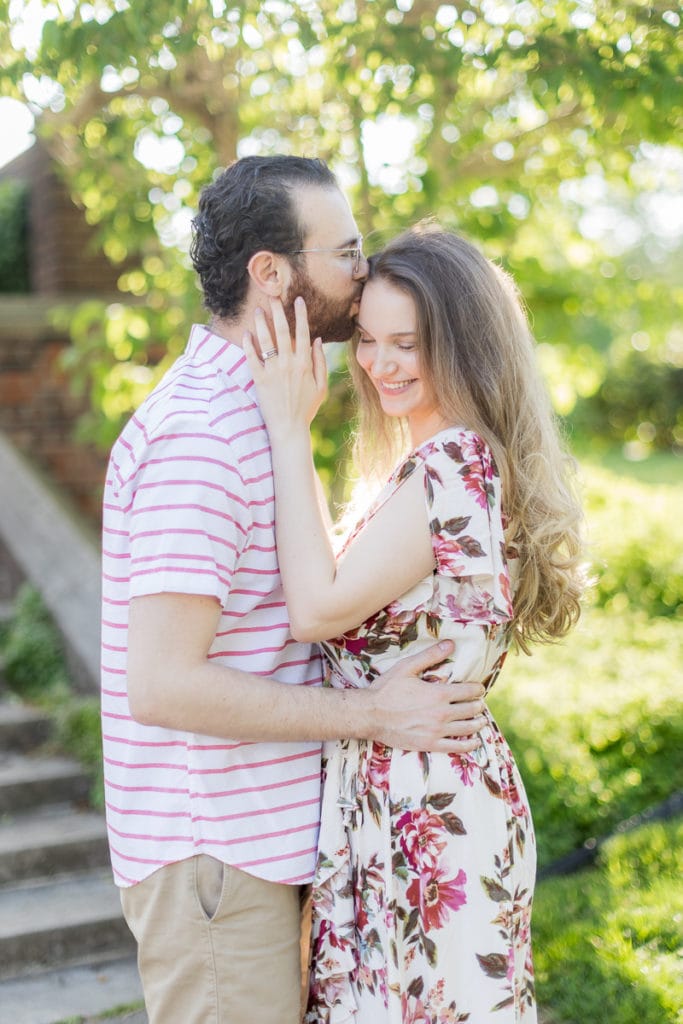 man kissing woman on the forehead