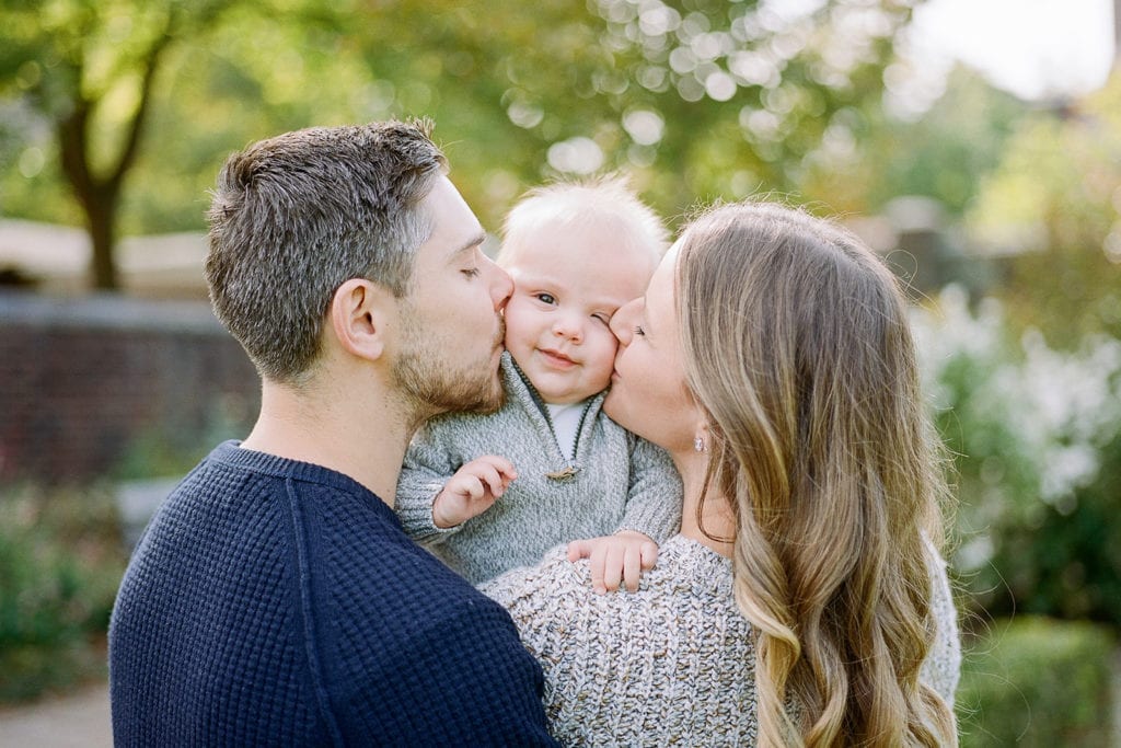 Parents kissing baby's cheeks during family photo session with Lauren Renee