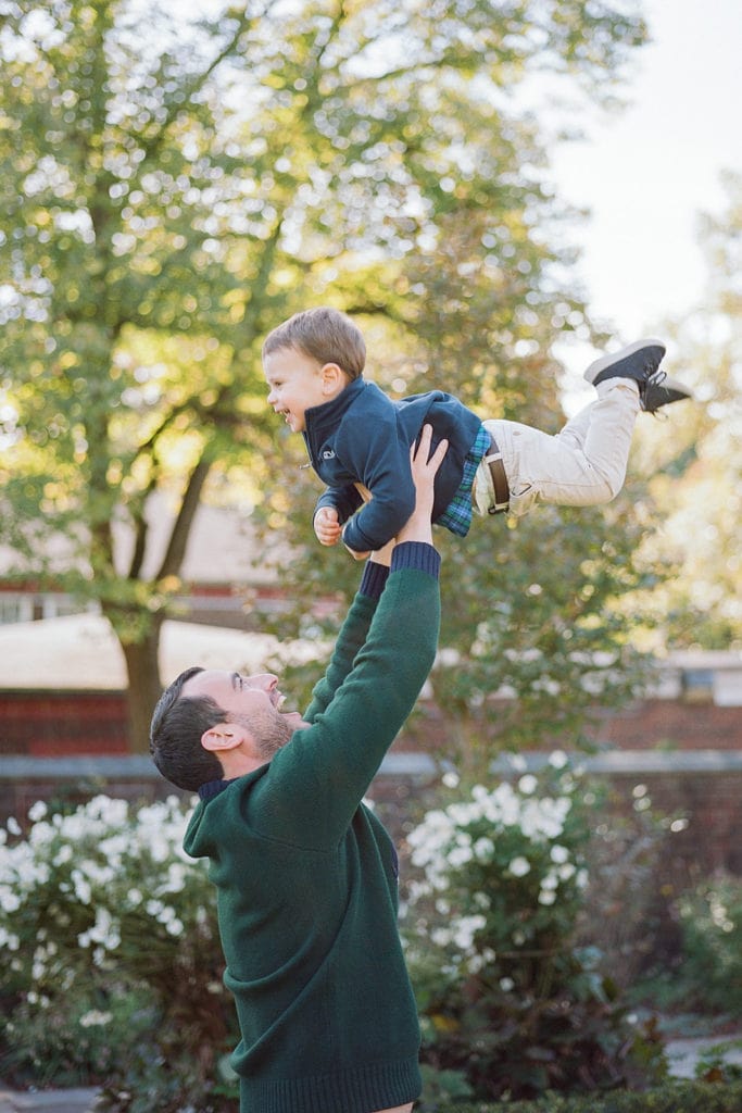 Dad lifting up son during family photos by Lauren Renee