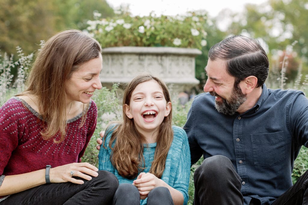 Mom and dad laughing with their daughter