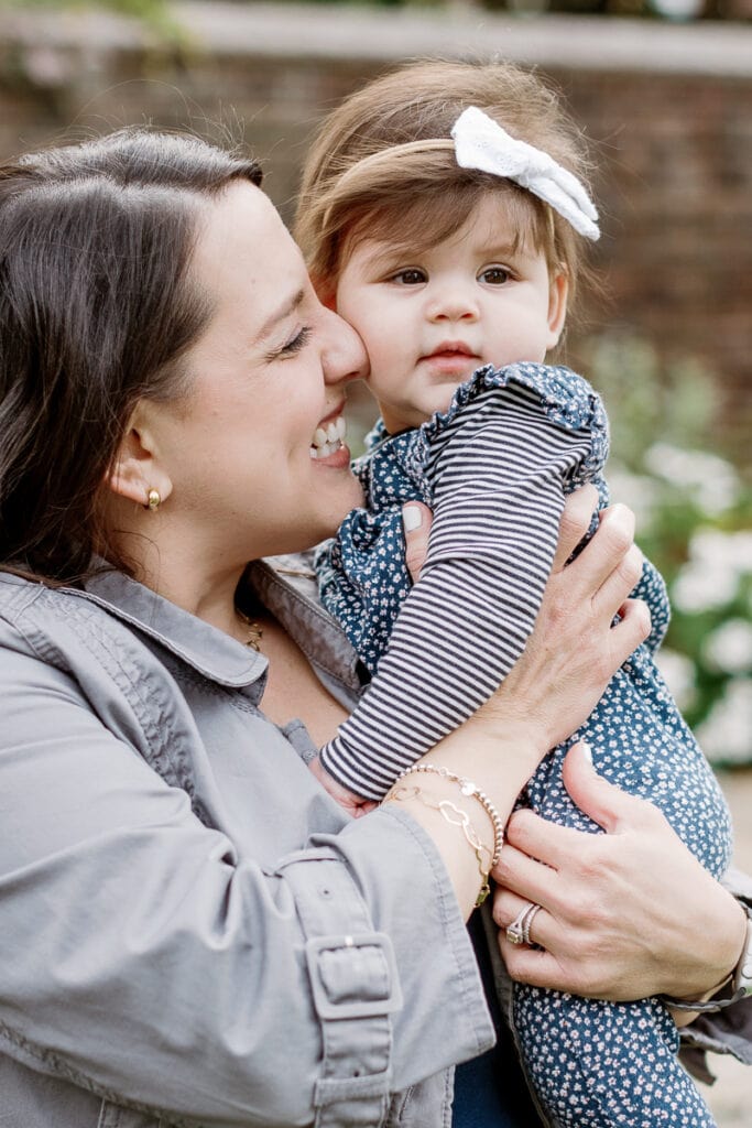 Mom holding her daughter with a bow in her hair