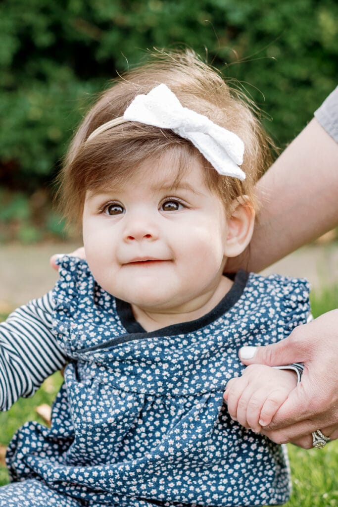 Baby girl smiling with a bow mini sessions at Mellon Park