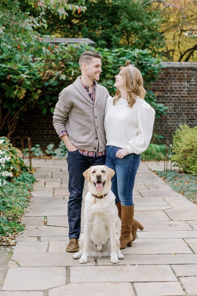 Couple looking at one another with their dog posing in between them