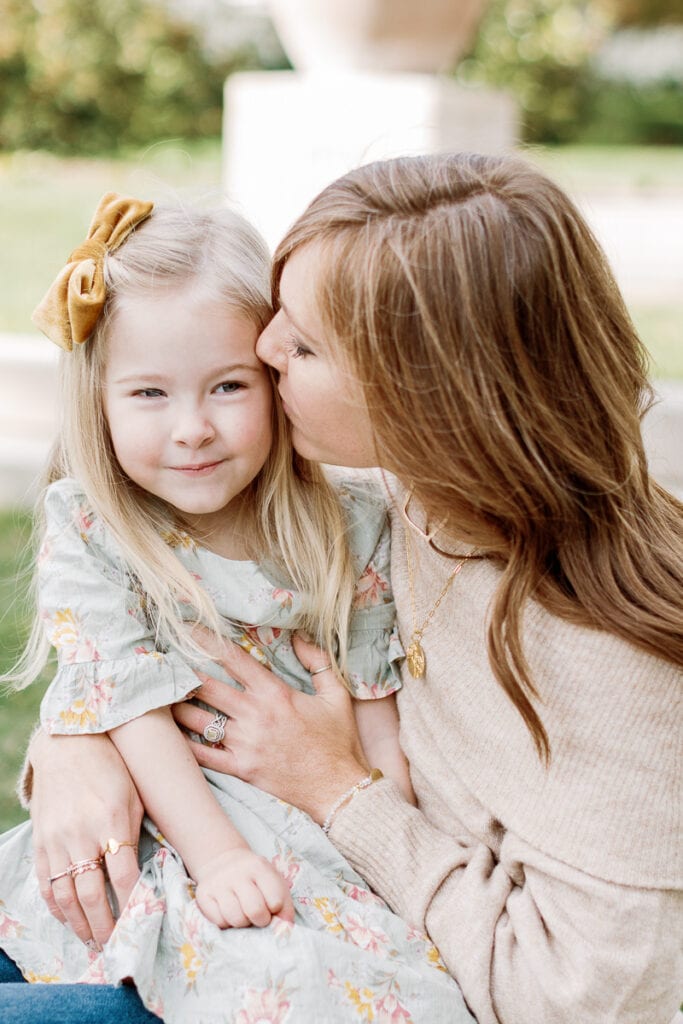 Mom kissing her daughter on the cheek