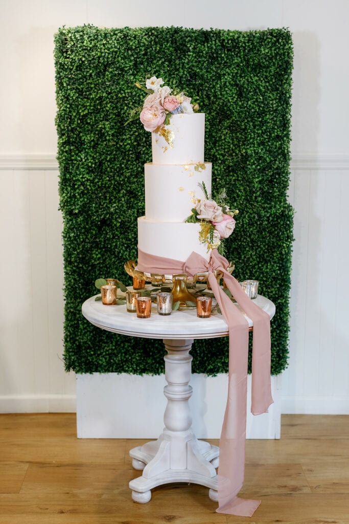 Luxurious pink and white wedding cake with flowers and a bow