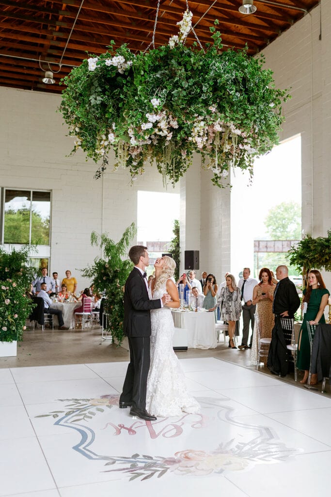 First dance under greenery floral wedding chandelier