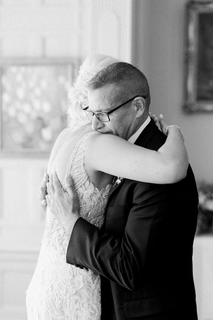 Bride and father of the bride hugging