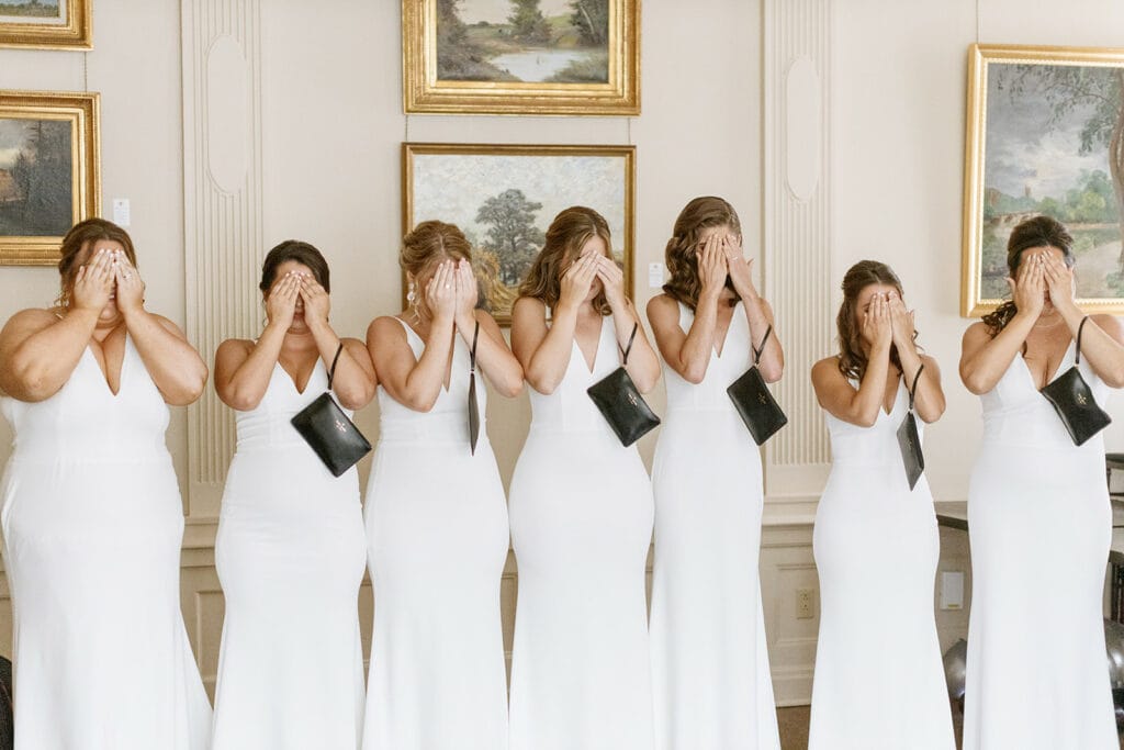 Bridesmaids in white bridesmaid dresses during bride's first look