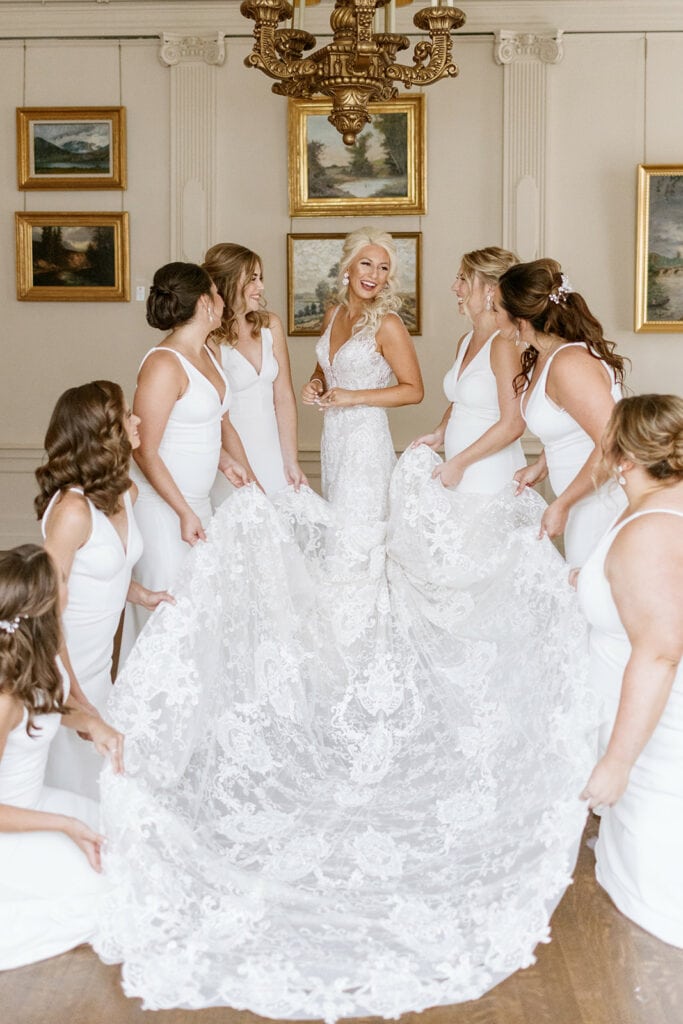 Bridesmaids posing with bride's wedding dress