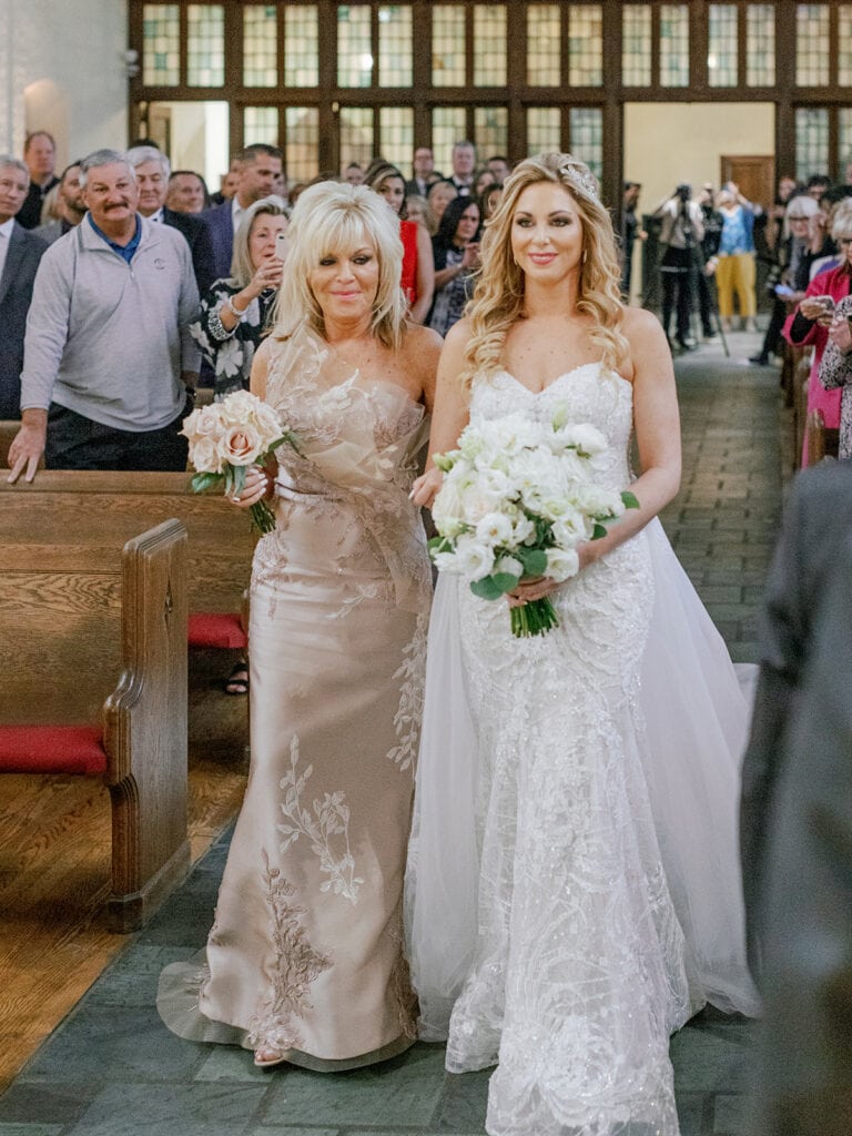 Mother of the bride escorting bride down the aisle