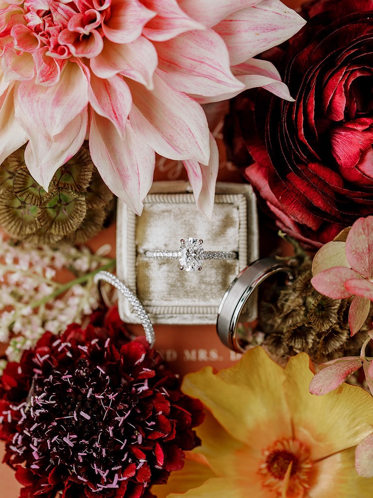 Photo of engagement and wedding rings in a flatlay at an outdoor Pittsburgh wedding.