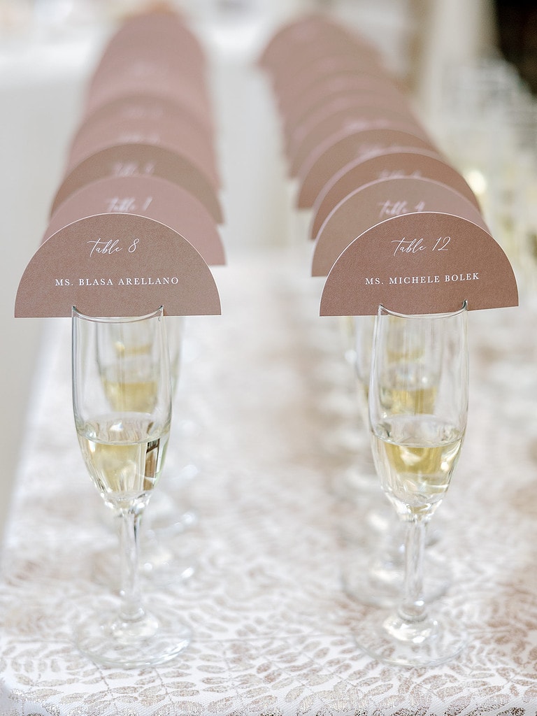 Photo of champagne escort cards at a luxury wedding.