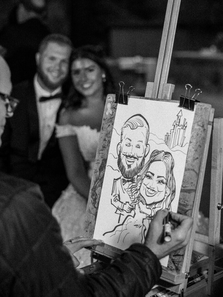 Photo of bride and groom getting a caricature at their wedding reception.