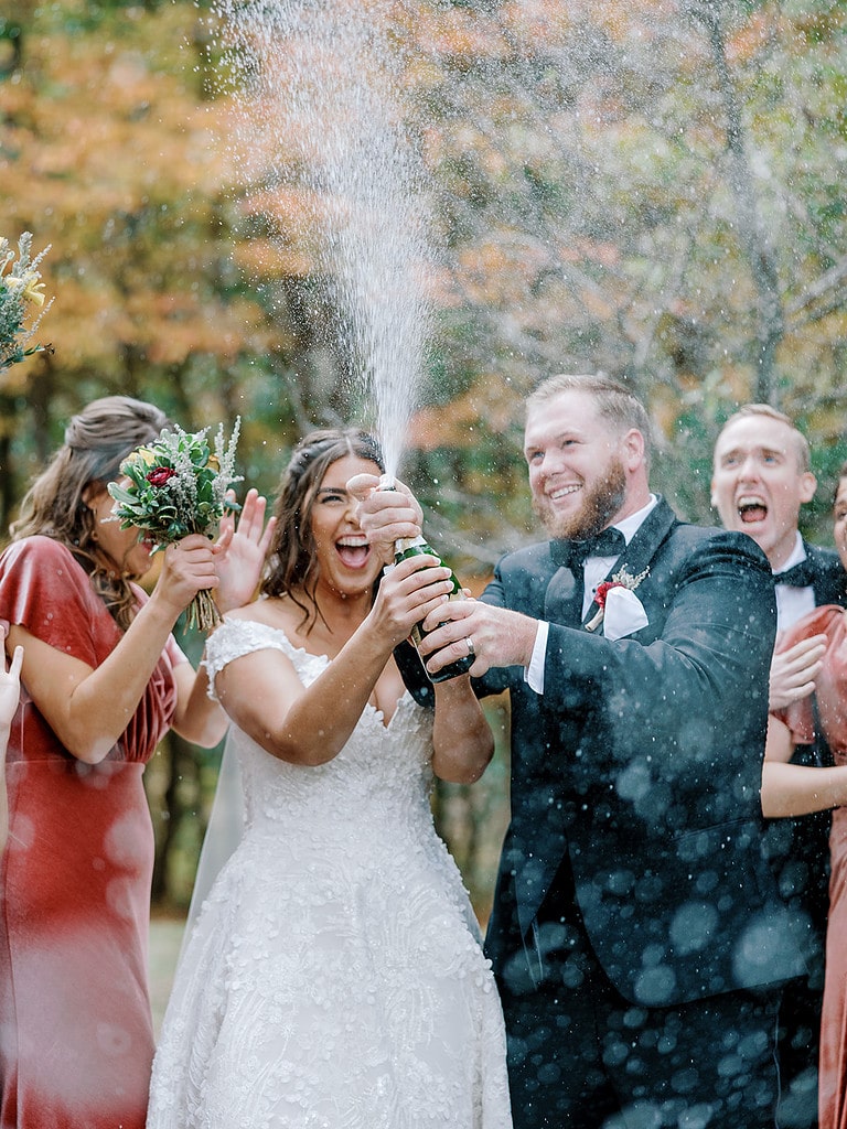 Photo of bride and groom popping champagne with bridesmaids and groomsmen in Pittsburgh.