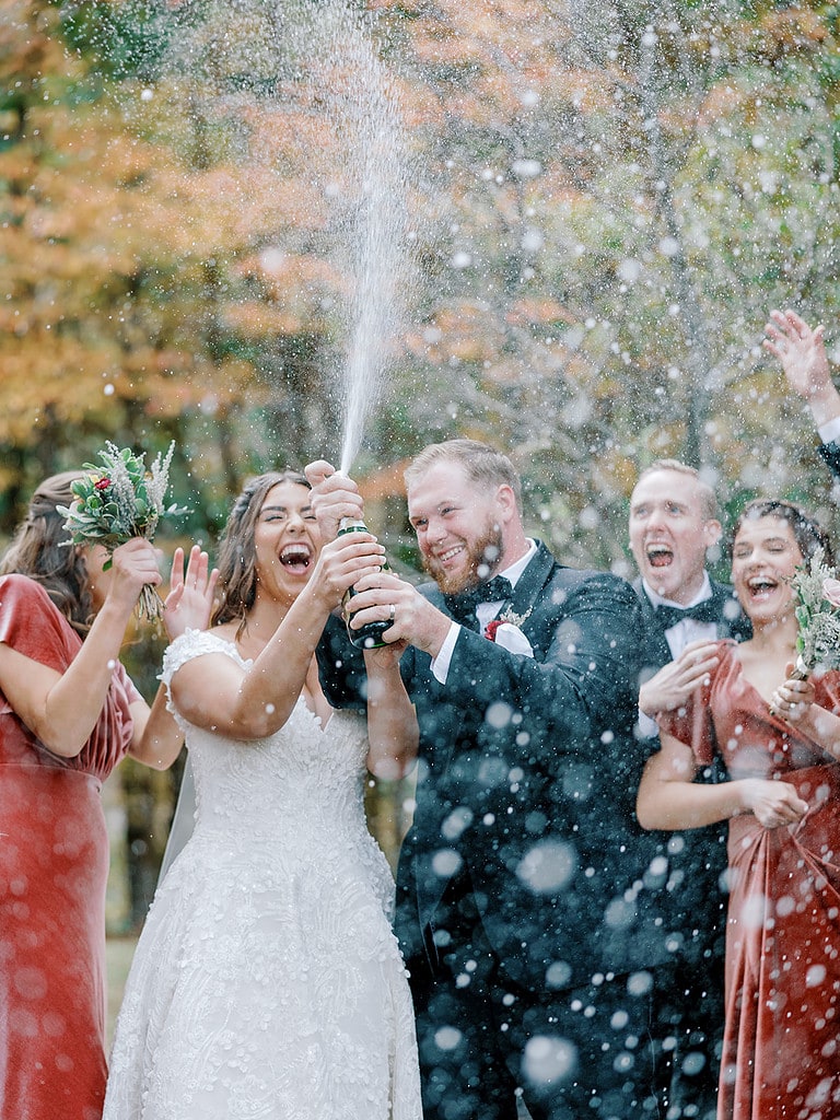 Photo of bride and groom popping champagne at a Pennsylvania wedding.
