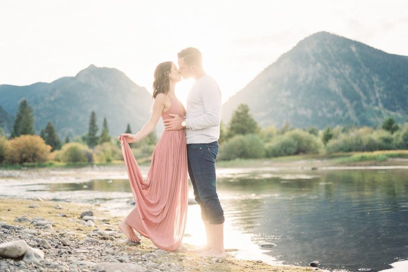 Man and woman kiss during sunset over lake Dillon Colorado