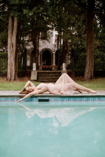 Russian beauty laying by the pool wearing for Love and Lemons pink lingerie