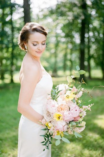 bride holding pink and orange bouquet in sunlight