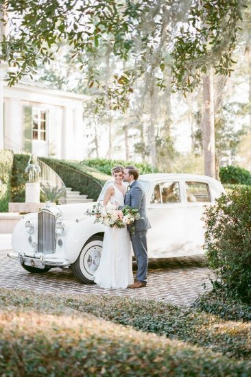 Bride and Groom standing in front of a white Rolls Royce