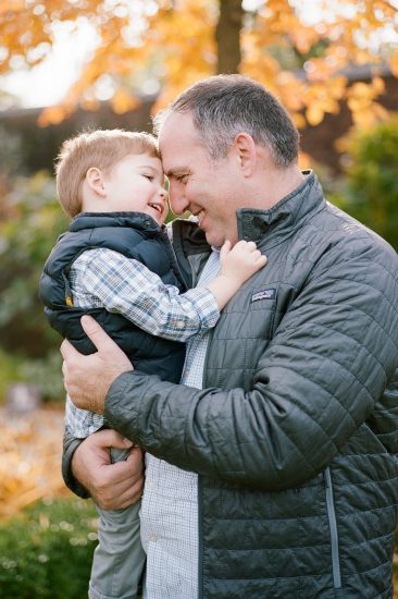 Dad embracing his son and touching foreheads during photos