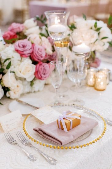 Place setting with gold rimmed china and pink and white flowers