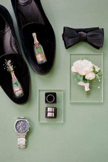 groom's details black tux velvet shoes with champagne bottle