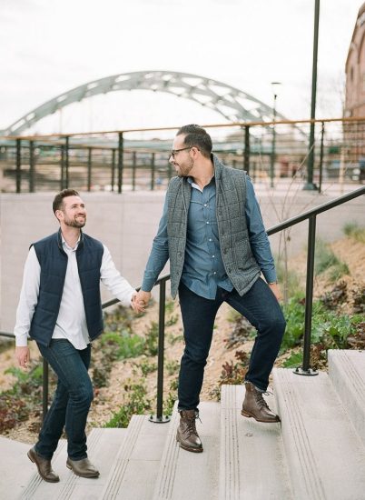 Estes Park Engagement Photography Session - gay couple walking up stairs and looking at each other
