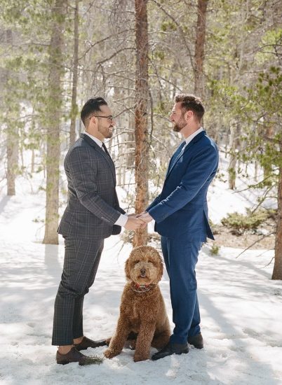 Estes Park Engagement Photography Session - two gay men holding hands in the snow with their dog