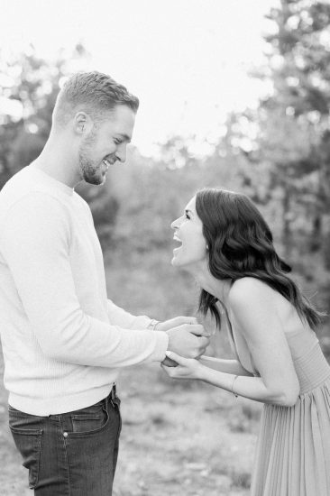 Couple laughing together while holding hands black and white photo